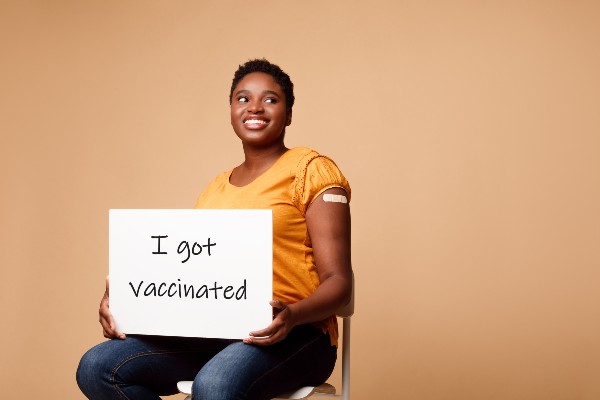 Black woman holding a sign saying I got vaccinated