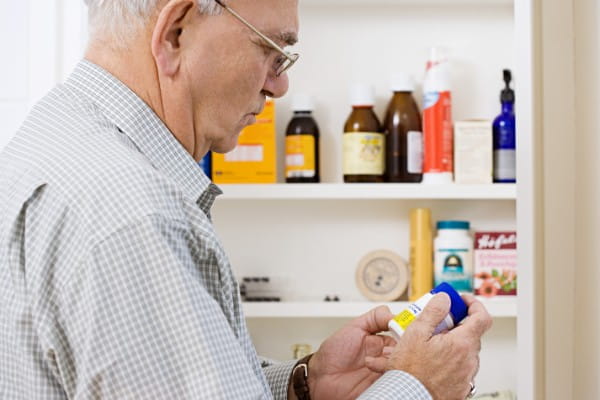 older man looking at his medicine cabinet