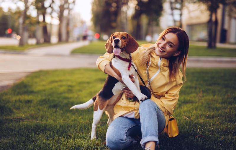 Cheerful lady with dog on grass