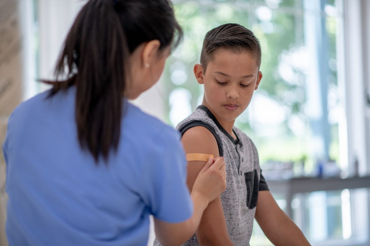 Nurse giving kid a shot