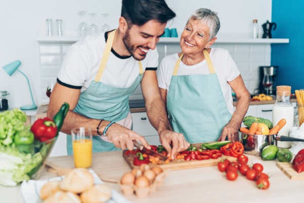 Mother and adult son making salad together