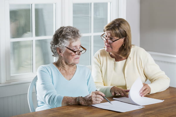 Older woman and younger woman viewing papers