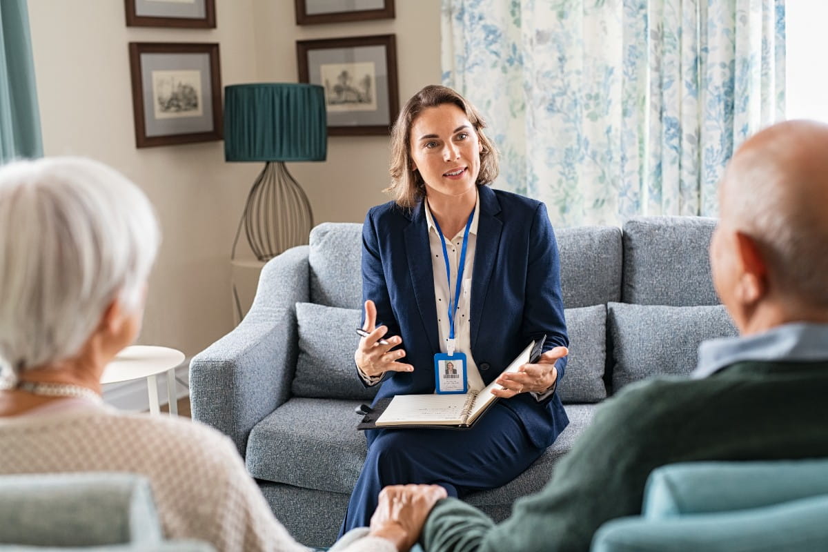 social worker talking to senior couple at home