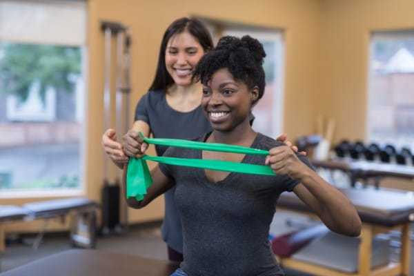 A physical therapist of Asian descent works with her patient