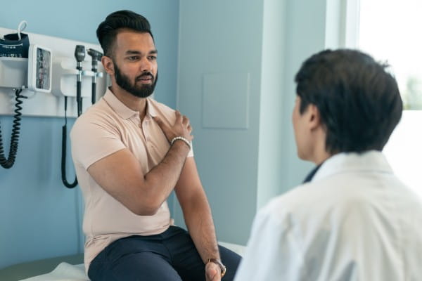 A mixed-race man is at a routine medical appointment.