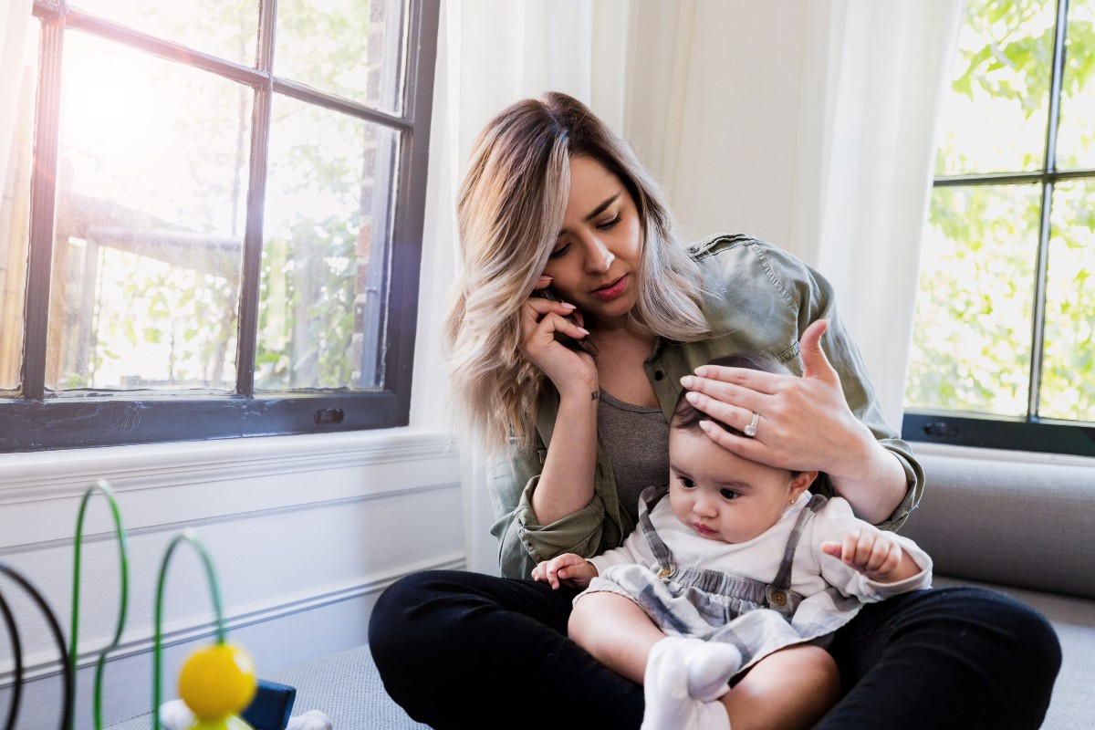 Mid adult mother calls doctor because baby has fever