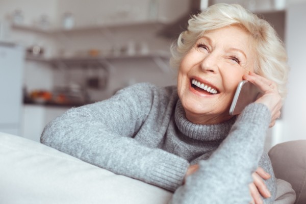 older woman talking on the phone in her house