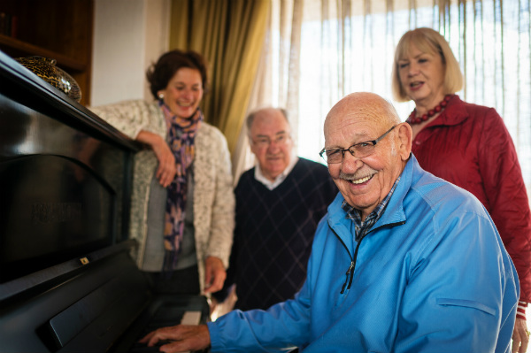 Seniors at a piano laughing together