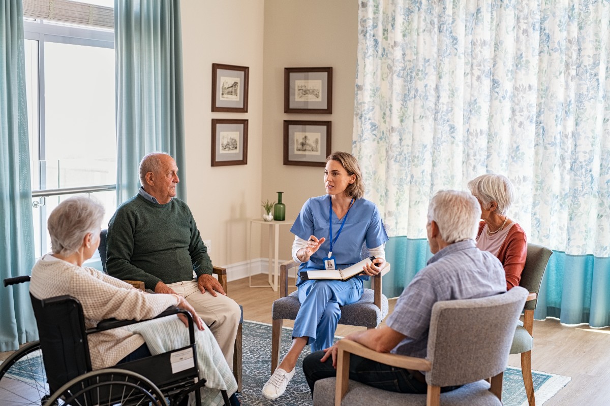 Group of senior people listening to young nurse. 