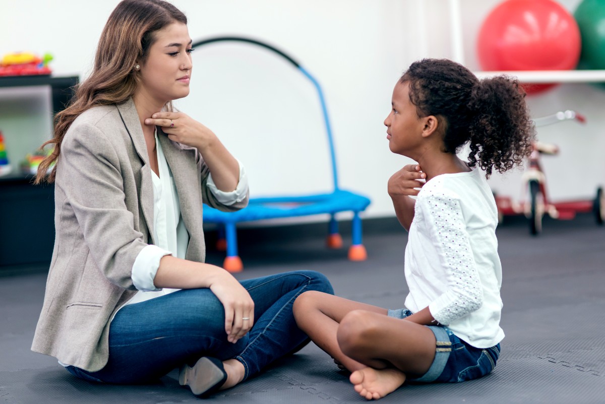 Female speech therapist assisting young African American girl