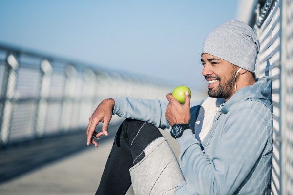 African American man lives a healthy life eating a green apple