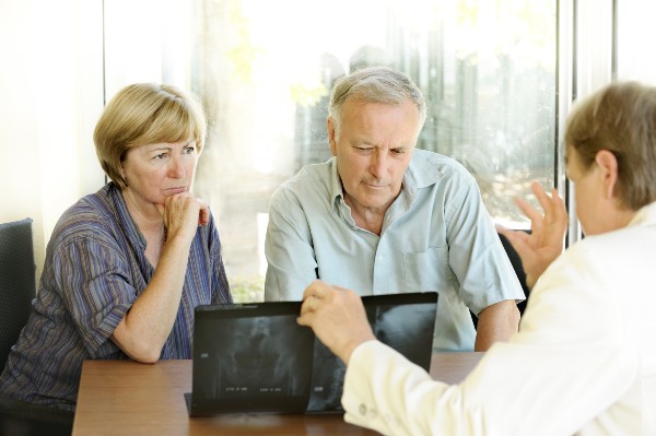 A specialist explains X-rays to an anxious couple.