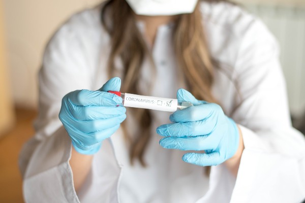 Nurse wearing respirator mask holding a positive blood test