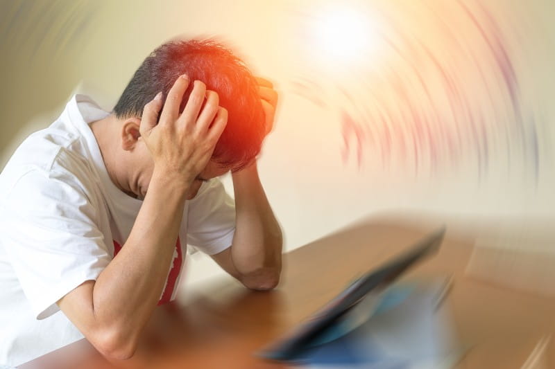 Male adult looking tired and stressed out holding his head