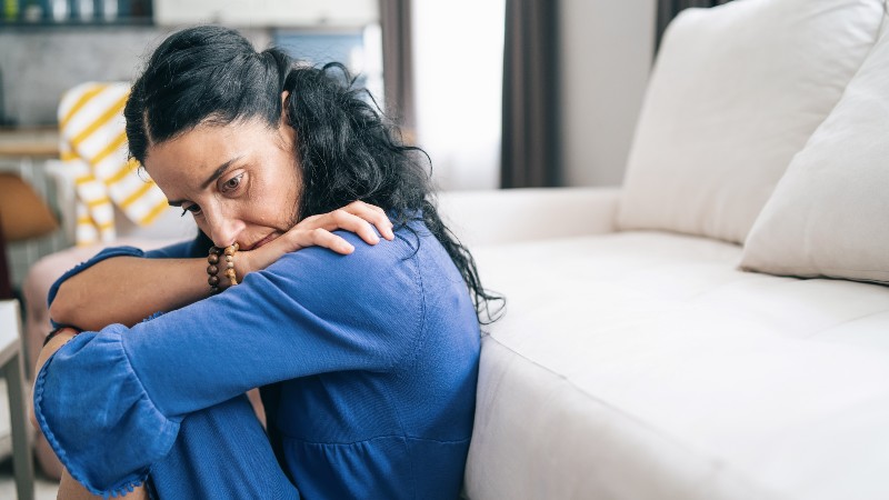 Mid adult woman in isolation looking sad