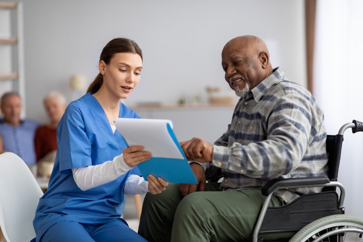  young nurse helping senior black man with questionnaire