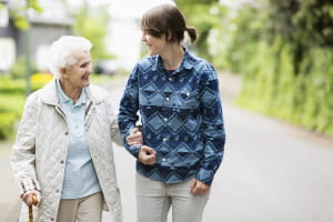 Older-woman-linking-arm-with-younger-woman-on-walk