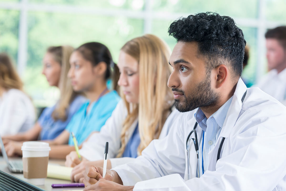 Attentive medical student takes notes during class