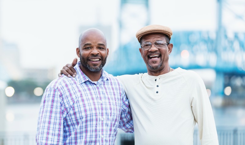 african american men standing next to eachother and smililng